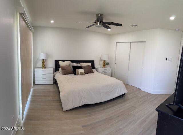 bedroom with ceiling fan, a closet, and light hardwood / wood-style flooring