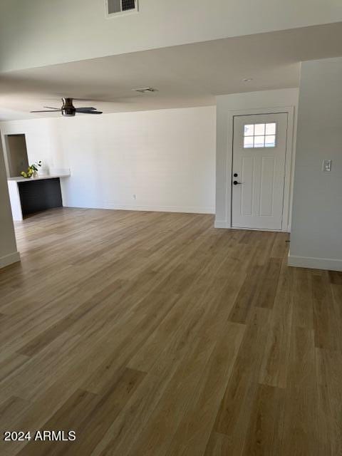 interior space with wood-type flooring and ceiling fan