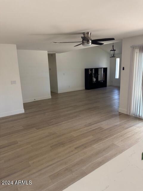 unfurnished living room featuring ceiling fan and wood-type flooring