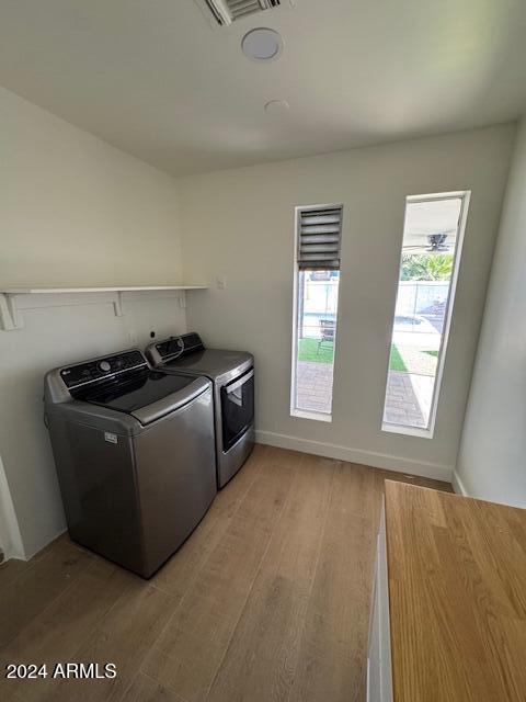 laundry area featuring washer and dryer and light wood-type flooring