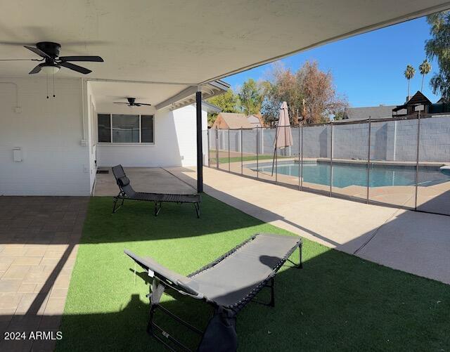 view of patio featuring a fenced in pool and ceiling fan