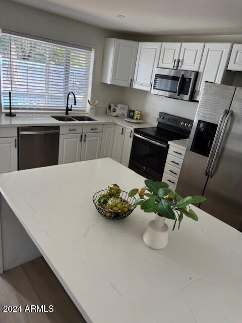 kitchen featuring light stone countertops, sink, white cabinetry, and stainless steel appliances