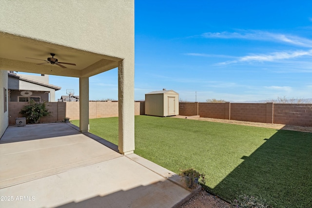 view of yard featuring a storage unit, ceiling fan, and a patio