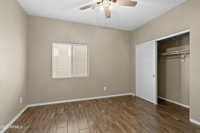 unfurnished bedroom with ceiling fan, dark wood-type flooring, and a closet