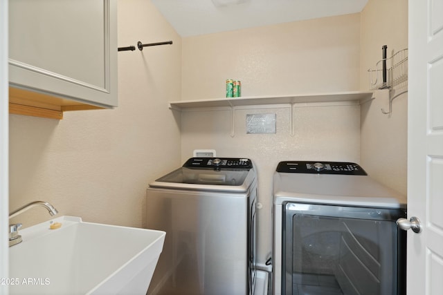 washroom with cabinets, sink, and washing machine and dryer