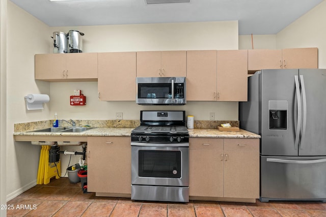 kitchen with light stone countertops, light brown cabinets, and stainless steel appliances