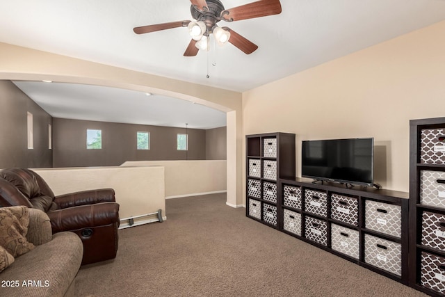 42160 W Arvada Ct, Maricopa, AZ 85138 - living room with carpet floors, arched walkways, a ceiling fan, and baseboards