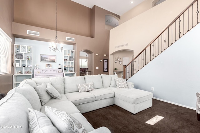 42160 W Arvada Ct, Maricopa, AZ 85138 - living area with arched walkways, a towering ceiling, a chandelier, baseboards, and dark colored carpet