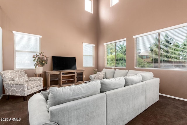 42160 W Arvada Ct, Maricopa, AZ 85138 - living room with dark colored carpet, baseboards, plenty of natural light, and a towering ceiling