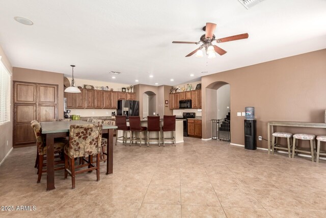 42160 W Arvada Ct, Maricopa, AZ 85138 - dining space featuring arched walkways, ceiling fan, baseboards, and light tile patterned flooring