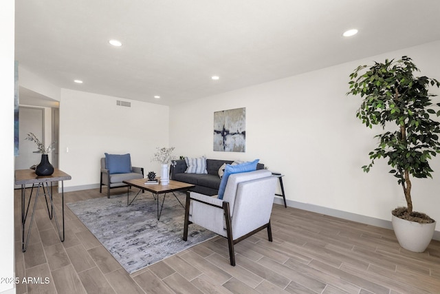 living room featuring visible vents, light wood-style floors, and recessed lighting
