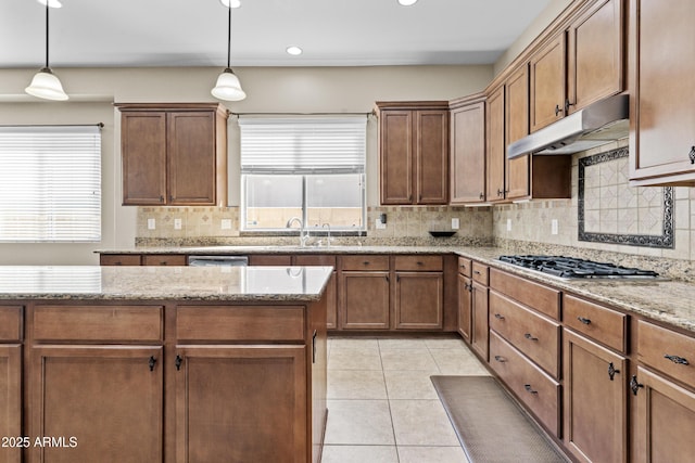 211 W New Dawn Dr, Chandler, AZ 85248 - kitchen featuring under cabinet range hood, a sink, decorative backsplash, stainless steel gas cooktop, and decorative light fixtures