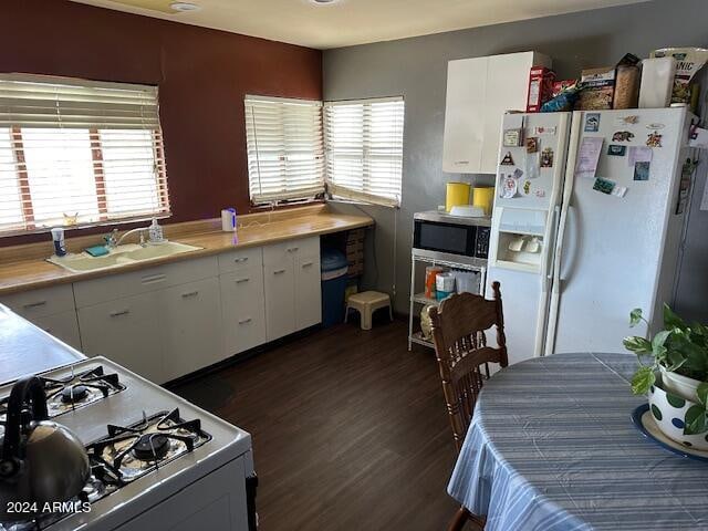 kitchen featuring white cabinetry, white appliances, sink, and dark hardwood / wood-style floors