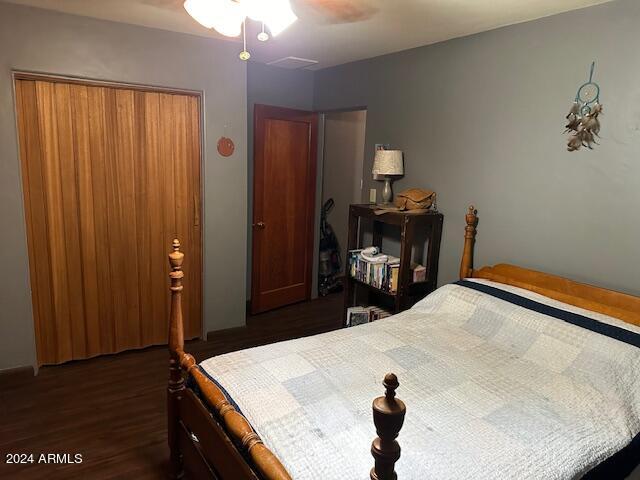 bedroom featuring dark hardwood / wood-style floors, ceiling fan, and a closet