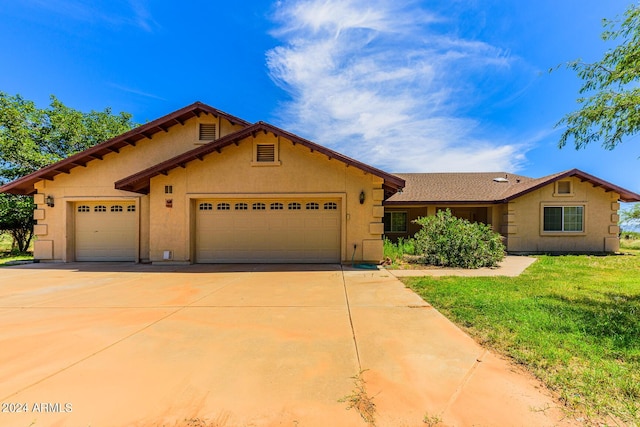 view of front facade with driveway, a front yard, an attached garage, and stucco siding