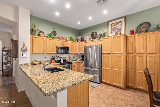 kitchen featuring kitchen peninsula, light stone countertops, stainless steel appliances, sink, and light tile patterned floors