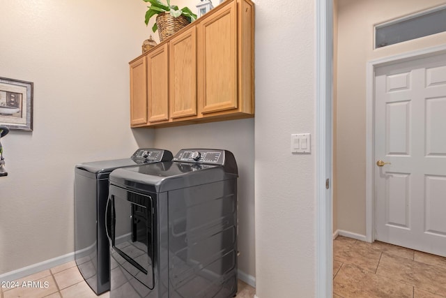 laundry room with cabinets, separate washer and dryer, and light tile patterned floors