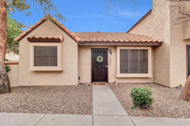 view of front facade featuring stucco siding and a tiled roof