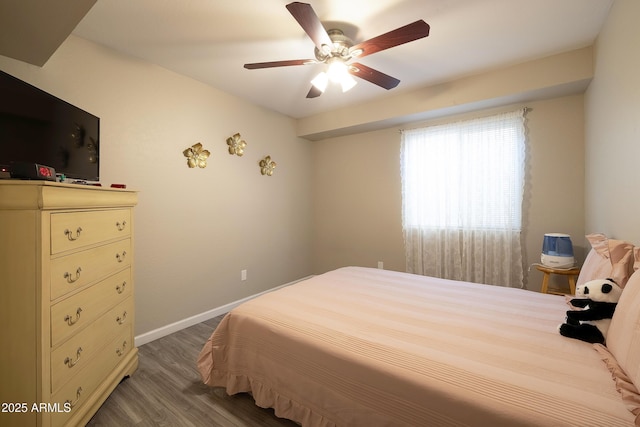 bedroom featuring wood finished floors, baseboards, and a ceiling fan