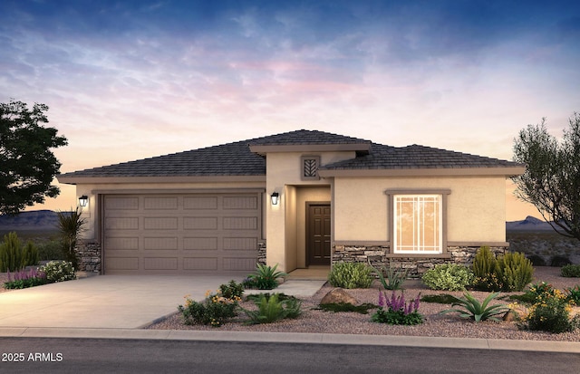 view of front of home with driveway, stucco siding, an attached garage, and stone siding
