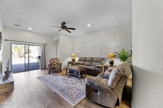 living room with visible vents, ceiling fan, wood finished floors, a decorative wall, and recessed lighting