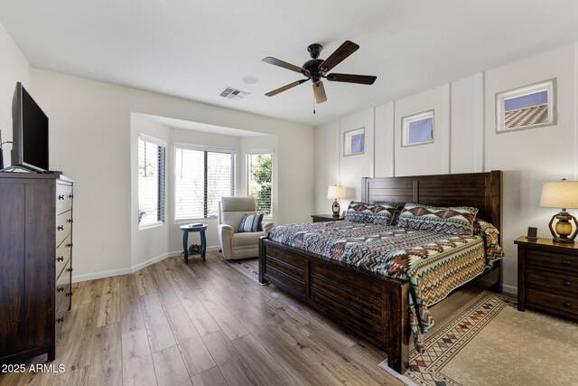 bedroom featuring light wood-style floors, visible vents, ceiling fan, and baseboards