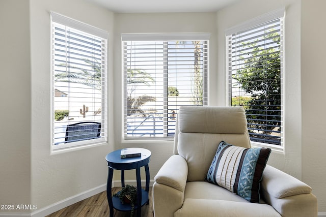 living area with plenty of natural light, wood finished floors, and baseboards