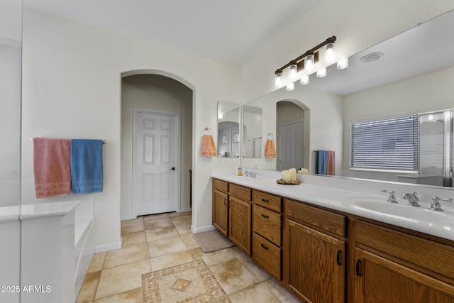 full bathroom featuring tile patterned flooring, a sink, baseboards, and double vanity