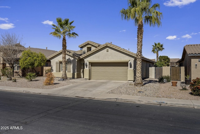 view of front of house featuring a garage, fence, driveway, a tiled roof, and stucco siding