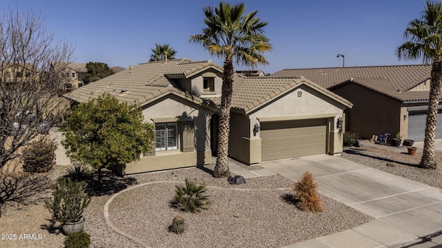 view of front of house featuring a tiled roof, an attached garage, driveway, and stucco siding