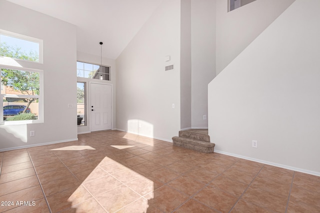 tiled entryway with a healthy amount of sunlight and high vaulted ceiling