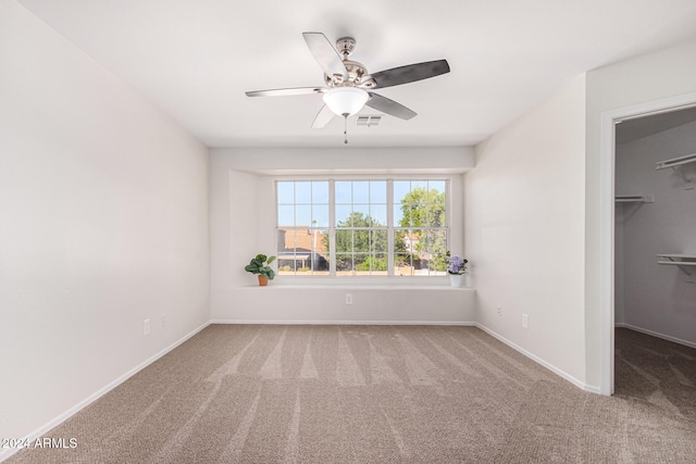 unfurnished bedroom with a spacious closet, carpet floors, a closet, and ceiling fan