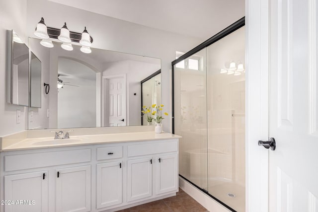 bathroom with a shower with door, vanity, tile patterned floors, and ceiling fan