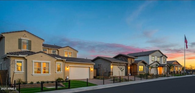 view of front facade featuring a fenced front yard, a garage, stucco siding, and a tiled roof