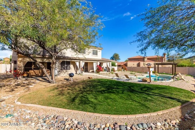 back of property featuring a yard, a fenced in pool, and a patio area