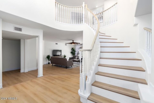 staircase featuring hardwood / wood-style flooring and ceiling fan