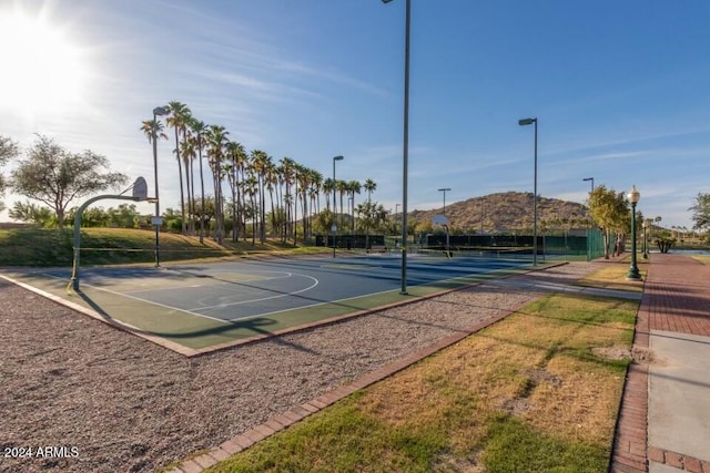 view of sport court featuring a mountain view and tennis court