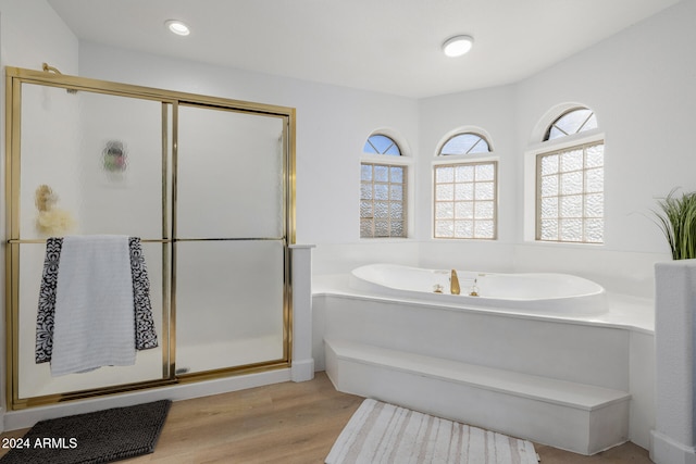 bathroom with wood-type flooring and separate shower and tub