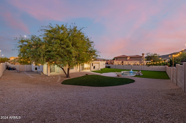 yard at dusk with a patio and a fenced in pool