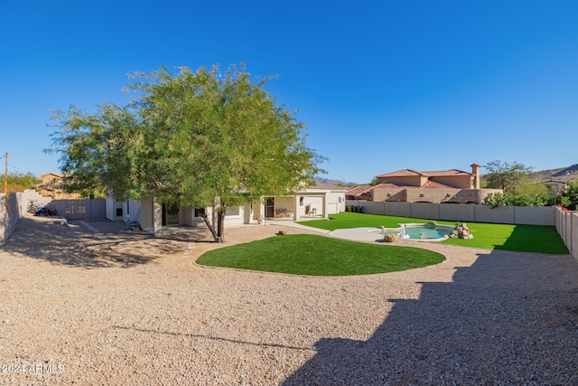 back of house featuring a lawn, a patio area, and a fenced in pool