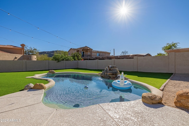 view of swimming pool featuring a yard