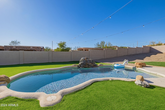 view of swimming pool featuring a yard