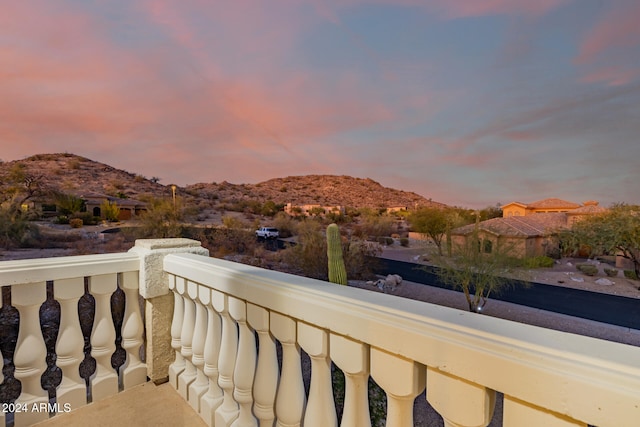 balcony at dusk featuring a mountain view