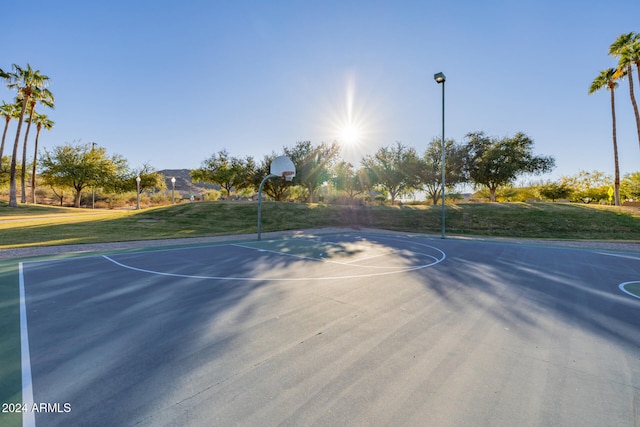 view of basketball court with a yard