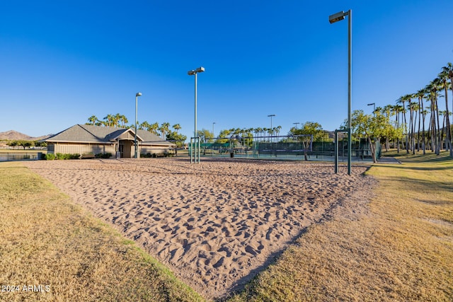 view of property's community with volleyball court and a yard