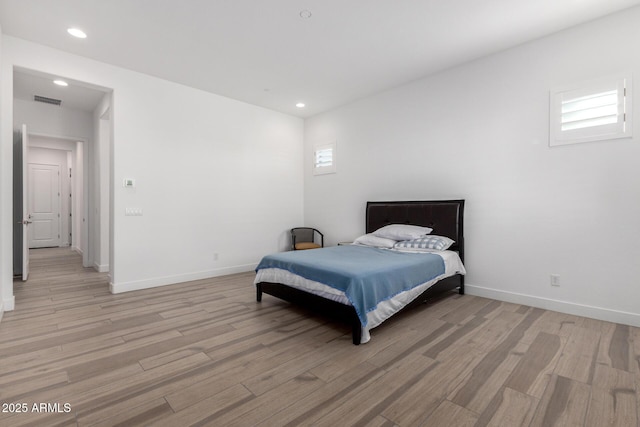 bedroom featuring multiple windows and light wood-type flooring