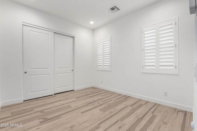 unfurnished bedroom with a closet and light hardwood / wood-style flooring