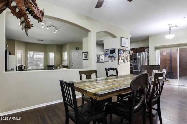 dining room with ceiling fan, visible vents, arched walkways, dark wood finished floors, and baseboards