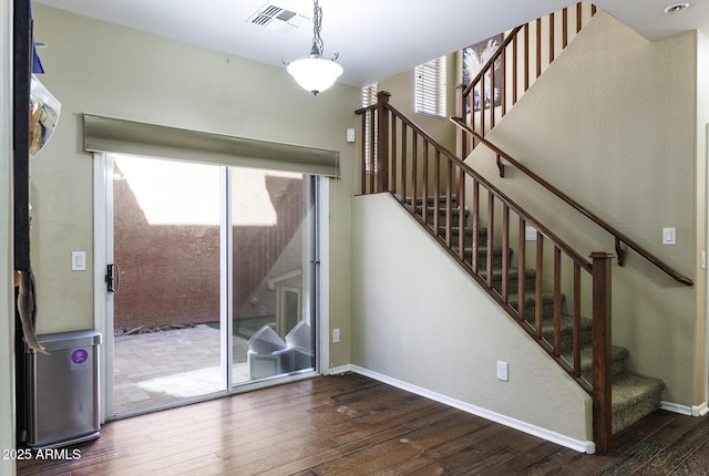 stairs featuring a healthy amount of sunlight, baseboards, hardwood / wood-style floors, and visible vents