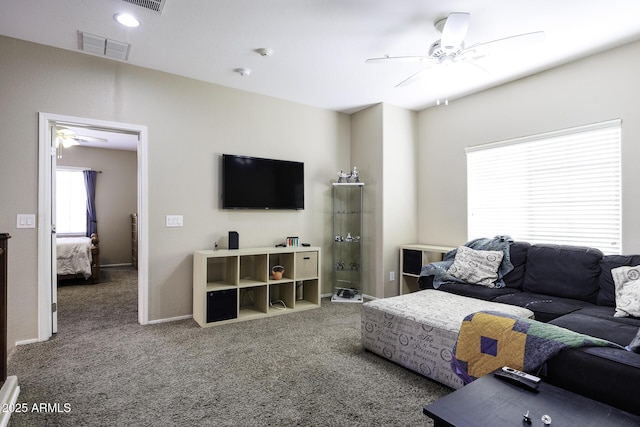 living area featuring ceiling fan, carpet flooring, and visible vents